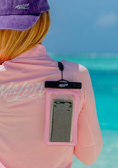 A Model carrying a Sub Oceanic Maldives Waterproof Phone Cover in Pink